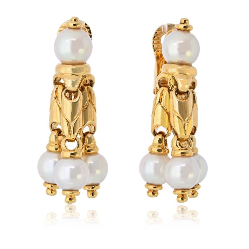 Bvlgari 18K Yellow Gold Dangle Earrings with Dopio Pearls: Bvlgari 18K Yellow Gold Dangle Earrings with Dopio Pearls These exquisite Bvlgari earrings are crafted from 18K yellow gold and showcase a stunning design that epitomizes elegance. The dangle style fe