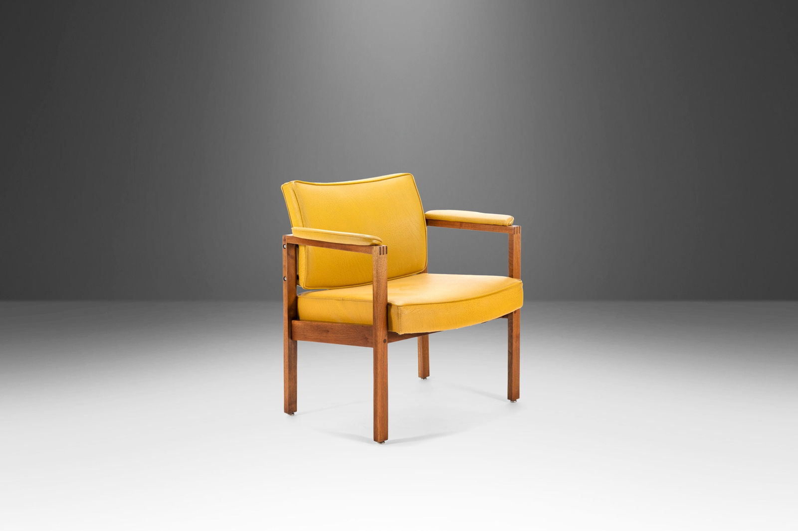 Mid-Century Modern Lounge Chair in Walnut with Mustard Vinyl by Jens Risom 1960s: Mid-Century Modern Lounge Chair in Walnut with Mustard Vinyl by Jens Risom 1960s This stunning lounge chair in walnut showcases the timeless design of the 1960s, reminiscent of Jens Risom's style. Cra