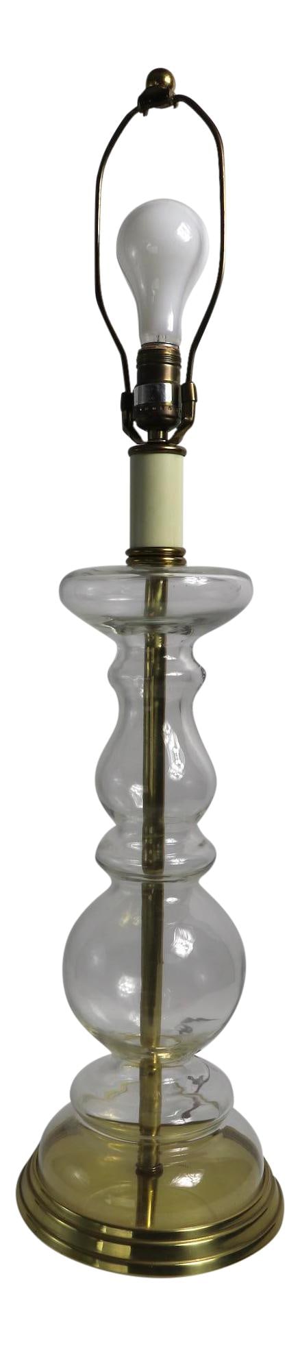 Tyndale Clear Glass Candlestick Table Lamp 34" Height: Tyndale Clear Glass Candlestick Table Lamp 34" Height Illuminate your space with this elegant clear glass table lamp designed in the form of a large candlestick by Tyndale. This stunning piece is craf
