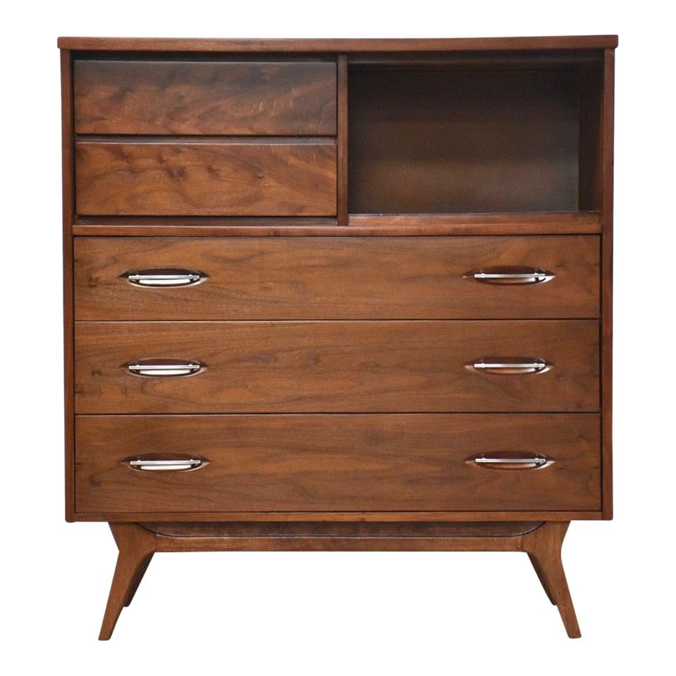 Mid Century Modern Walnut Tall Dresser by Hooker: Mid Century Modern Walnut Tall Dresser by Hooker This mid-century modern tall dresser is crafted from walnut and features distinctive canted legs along with durable steel drawer pulls. With a rich bro