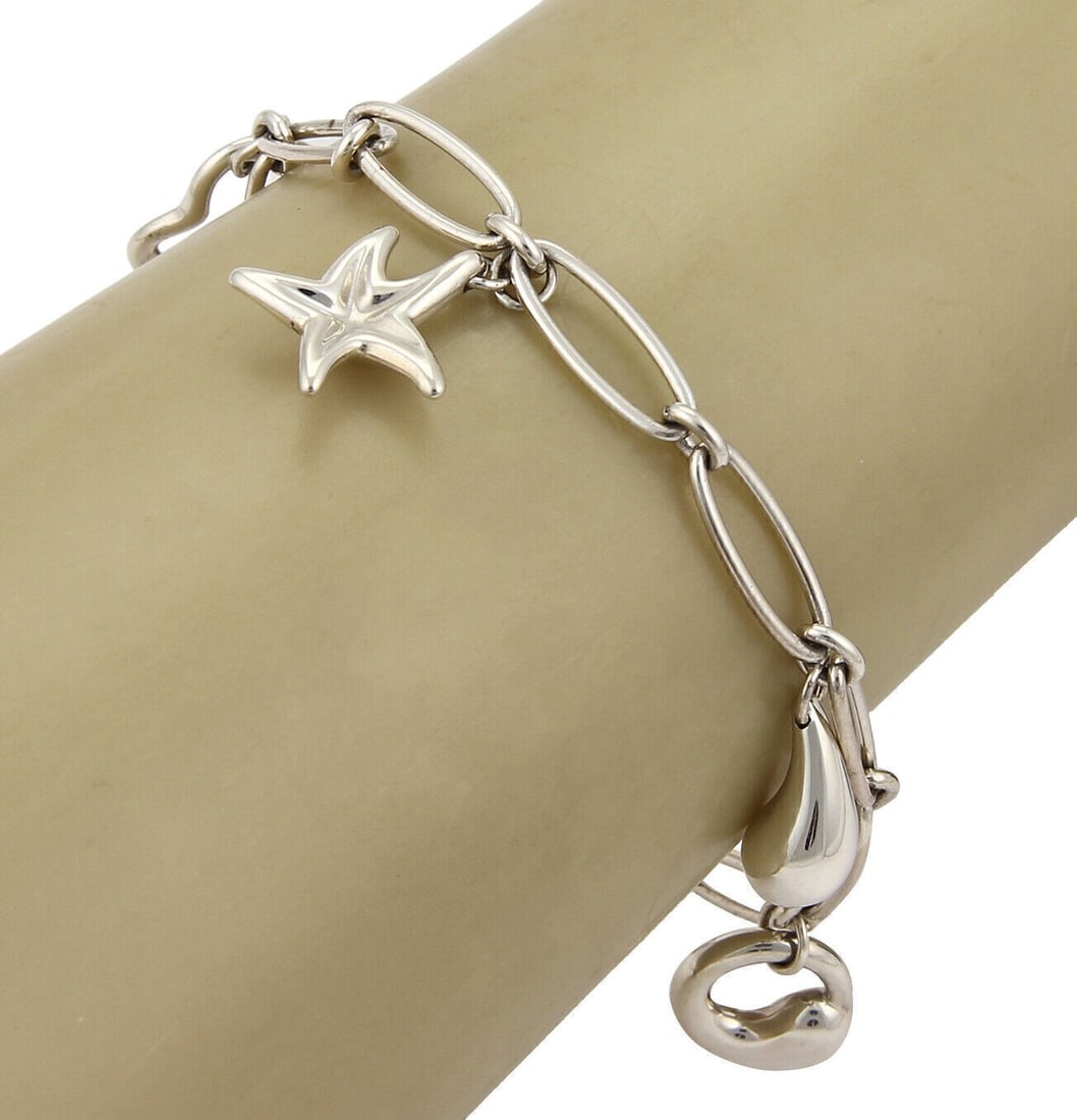 Tiffany & Co. Peretti Sterling Silver Charm Bracelet 5 Charms: Tiffany & Co. Peretti Sterling Silver Charm Bracelet 5 Charms Discover the elegance of the Tiffany & Co. Peretti Sterling Silver 5 Charms Oval Chain Bracelet, a vintage charm bracelet that embodies ti