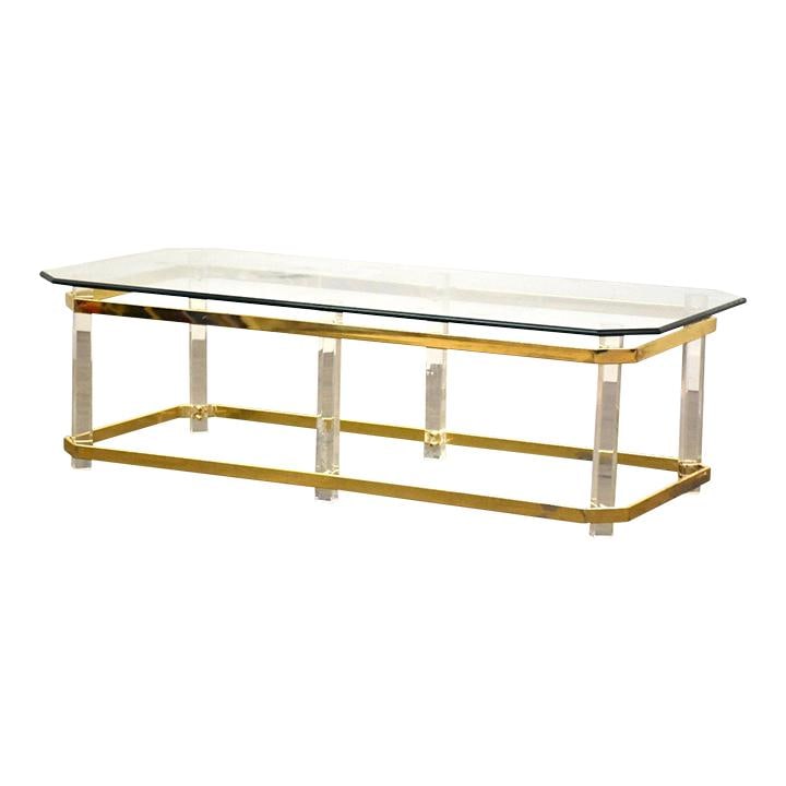 Modern Brass Lucite Glass Coffee Table 54 x 26 x 16.25: Modern Brass Lucite Glass Coffee Table 54 x 26 x 16.25 This stylish coffee table showcases a modern design featuring a sleek lucite and brass frame topped with a durable glass surface. Its generous di