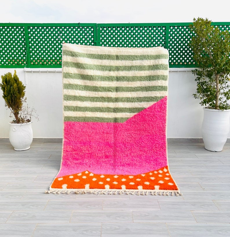 Authentic Handmade Moroccan Berber Wool Rug 8 x 5 Feet: Authentic Handmade Moroccan Berber Wool Rug 8 x 5 Feet Discover the charm of this stunning pink rug, beautifully handwoven by skilled Berber women in the Atlas Mountains of Morocco. Crafted using