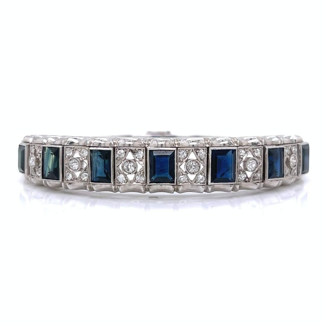 Art Deco Platinum Bangle Bracelet with Diamonds and Sapphires: Art Deco Platinum Bangle Bracelet with Diamonds and Sapphires This exquisite Art Deco bangle bracelet is crafted in platinum and features a stunning arrangement of 34 European-cut diamonds, totaling a