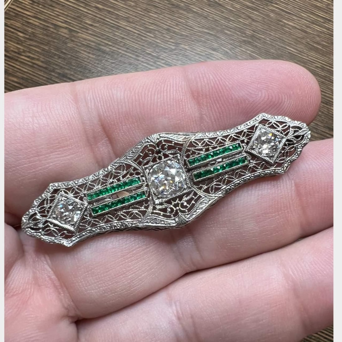 Vintage 1950's 14K White Gold Diamond Emerald Filigree Brooch: Vintage 1950's 14K White Gold Diamond Emerald Filigree Brooch This exquisite 1950's brooch is crafted from 14K white gold and features an intricate filigree design. At its center lies a stunning diamo