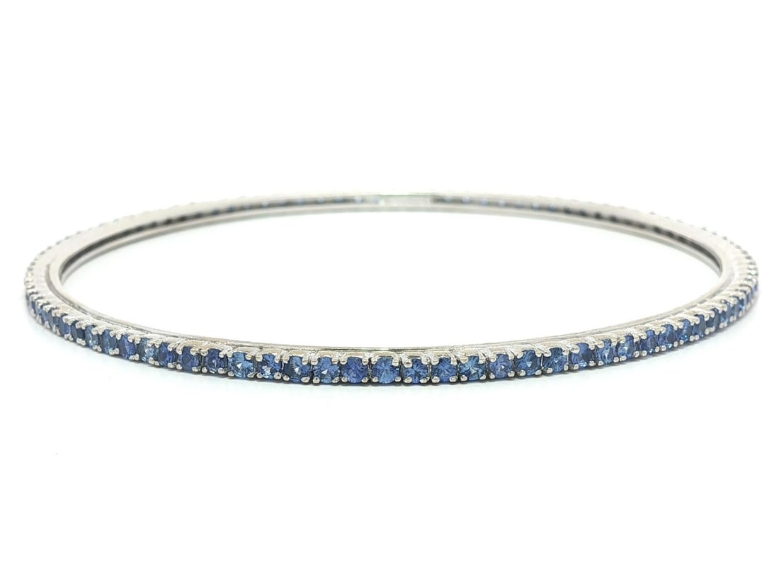 18k White Gold Tennis Bangle Bracelet with Cornflower Blue Sapphires: 18k White Gold Tennis Bangle Bracelet with Cornflower Blue Sapphires This elegant Solid 18k White Gold Tennis Bangle Bracelet is adorned with numerous natural genuine sapphires, each featuring a