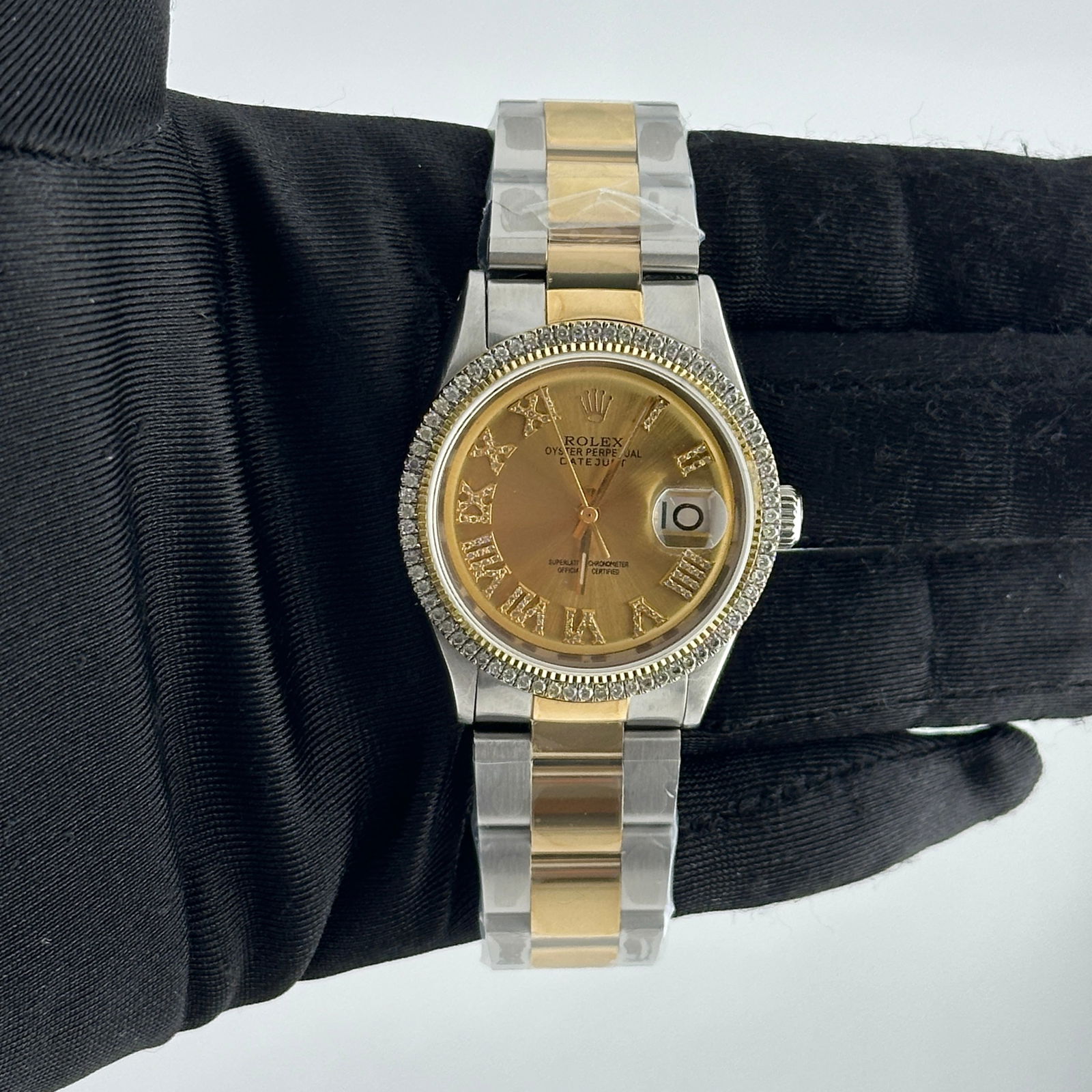 Aftermarket Diamond Roman Champagne Dial Oyster Watch Ref 1601: Aftermarket Diamond Roman Champagne Dial Oyster Watch Ref 1601 This Rolex Datejust features an aftermarket champagne dial with diamond Roman numerals, set within a prong-plated diamond bezel. The watc