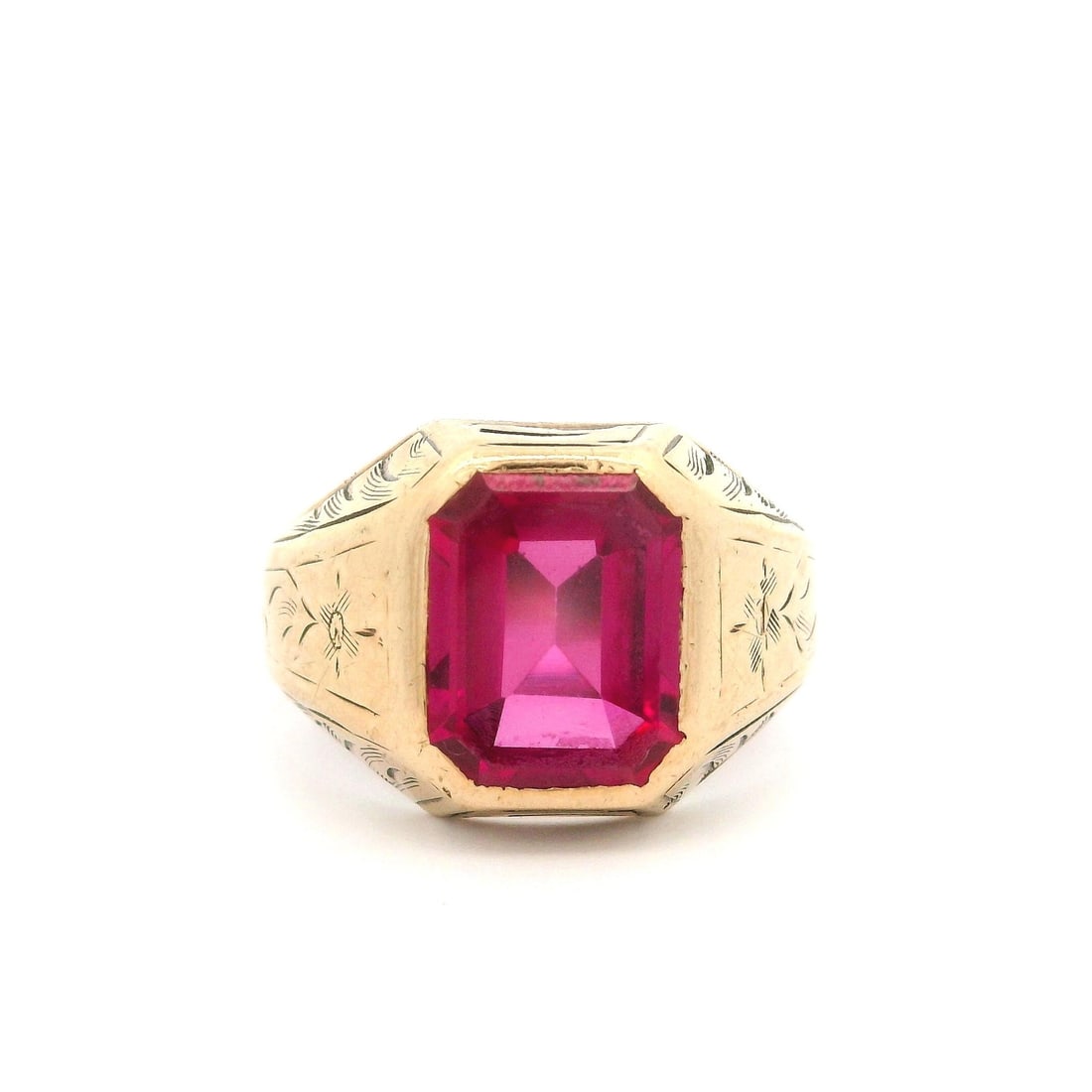Antique 10k Yellow Gold Engraved Cocktail Ring with Synthetic Ruby: Antique 10k Yellow Gold Engraved Cocktail Ring with Synthetic Ruby This exquisite antique cocktail ring is crafted from solid 10k yellow gold and features a striking synthetic ruby at its center. The