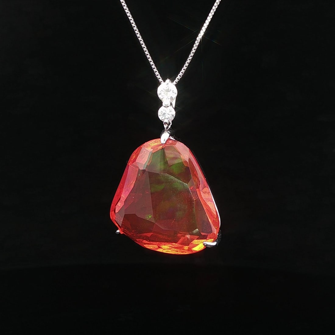Platinum Opal Diamond Pendant 14.3ct Adjustable Chain: Platinum Opal Diamond Pendant 14.3ct Adjustable Chain This stunning pendant features a large free form fire jelly opal, showcasing a fiery orange hue with captivating green play-of-color. The opal is