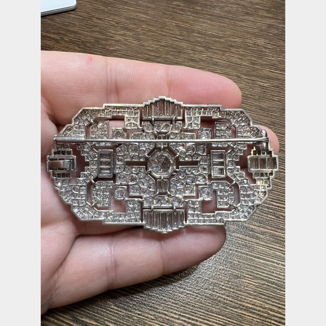 Art Deco Platinum Brooch 19.40 Ct Diamond Elegance: Art Deco Platinum Brooch 19.40 Ct Diamond Elegance This exquisite Art Deco brooch is crafted in platinum and adorned with a stunning array of diamonds. At its center, it features a prominent diamond w