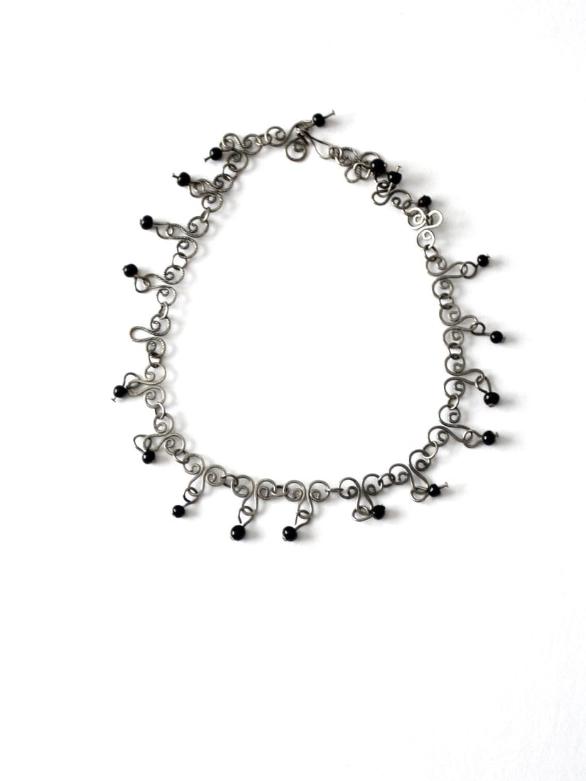 Vintage Filigree Choker Necklace with Black Beads: Vintage Filigree Choker Necklace with Black Beads This vintage choker necklace showcases an elegant filigree style chain adorned with black beads, complemented by a secure hook closure. Not only does