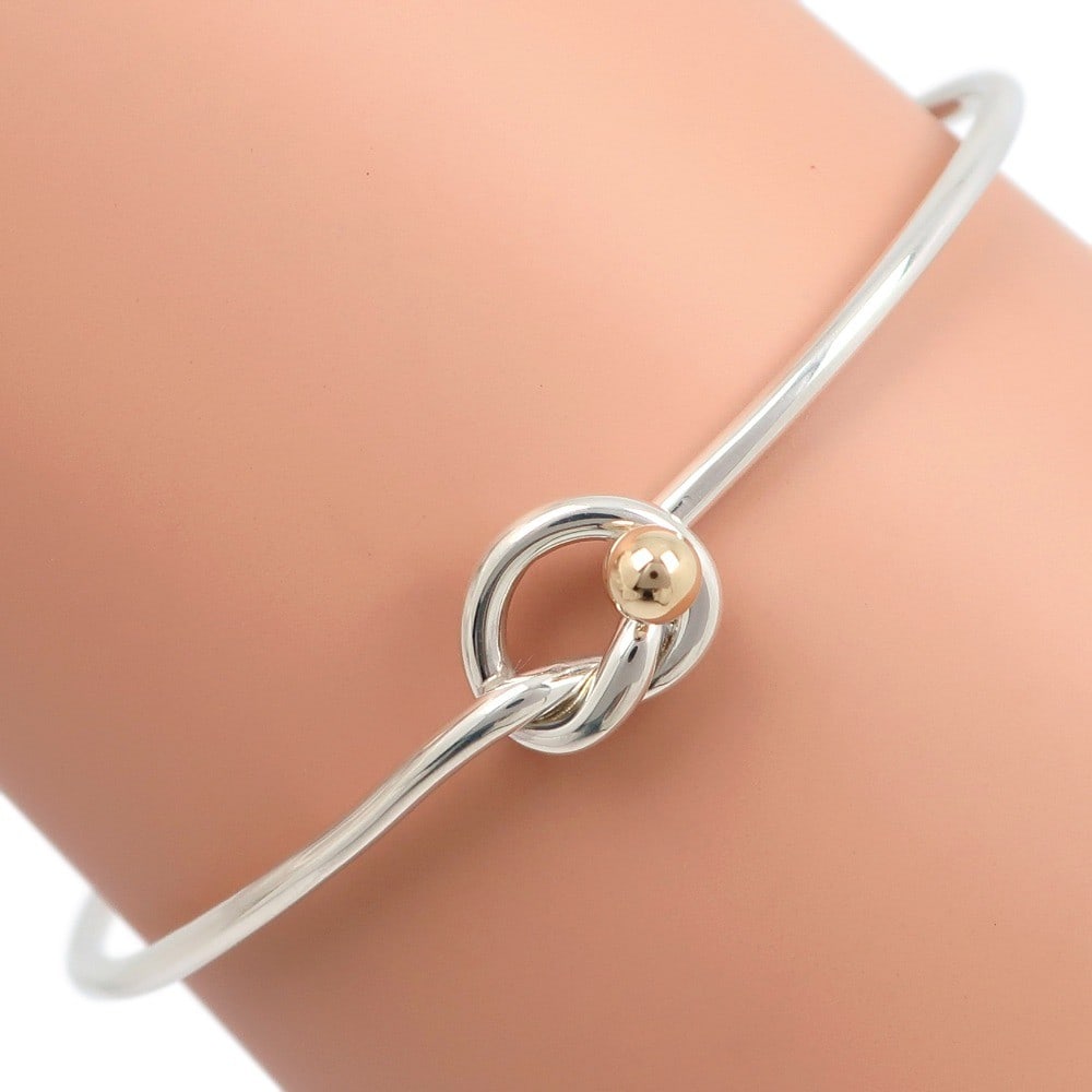 Love Knot Bracelet in Silver by Tiffany & Co.: Love Knot Bracelet in Silver by Tiffany & Co. This Tiffany & Co. Love Knot bracelet is crafted in silver with a polished finish and exhibits fine scratches. Designed for female wearers, it is in excel