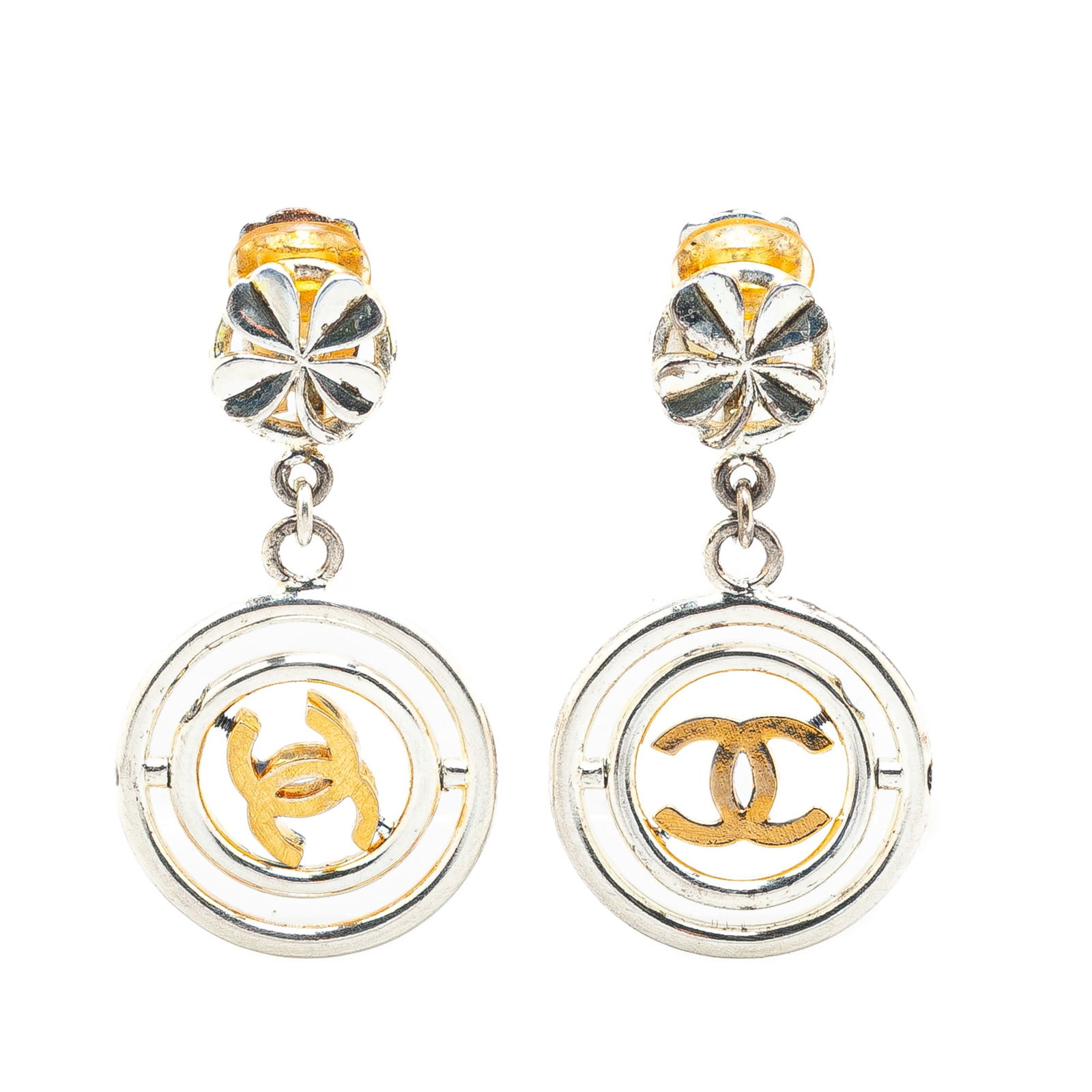 Chanel Silver Clover CC Drop Earrings with Gold Tone Charm: Chanel Silver Clover CC Drop Earrings with Gold Tone Charm Elevate your accessory game with these chic Chanel Silver Clover CC Drop Clip-On Earrings. Crafted with a stylish silver-tone body, these ear