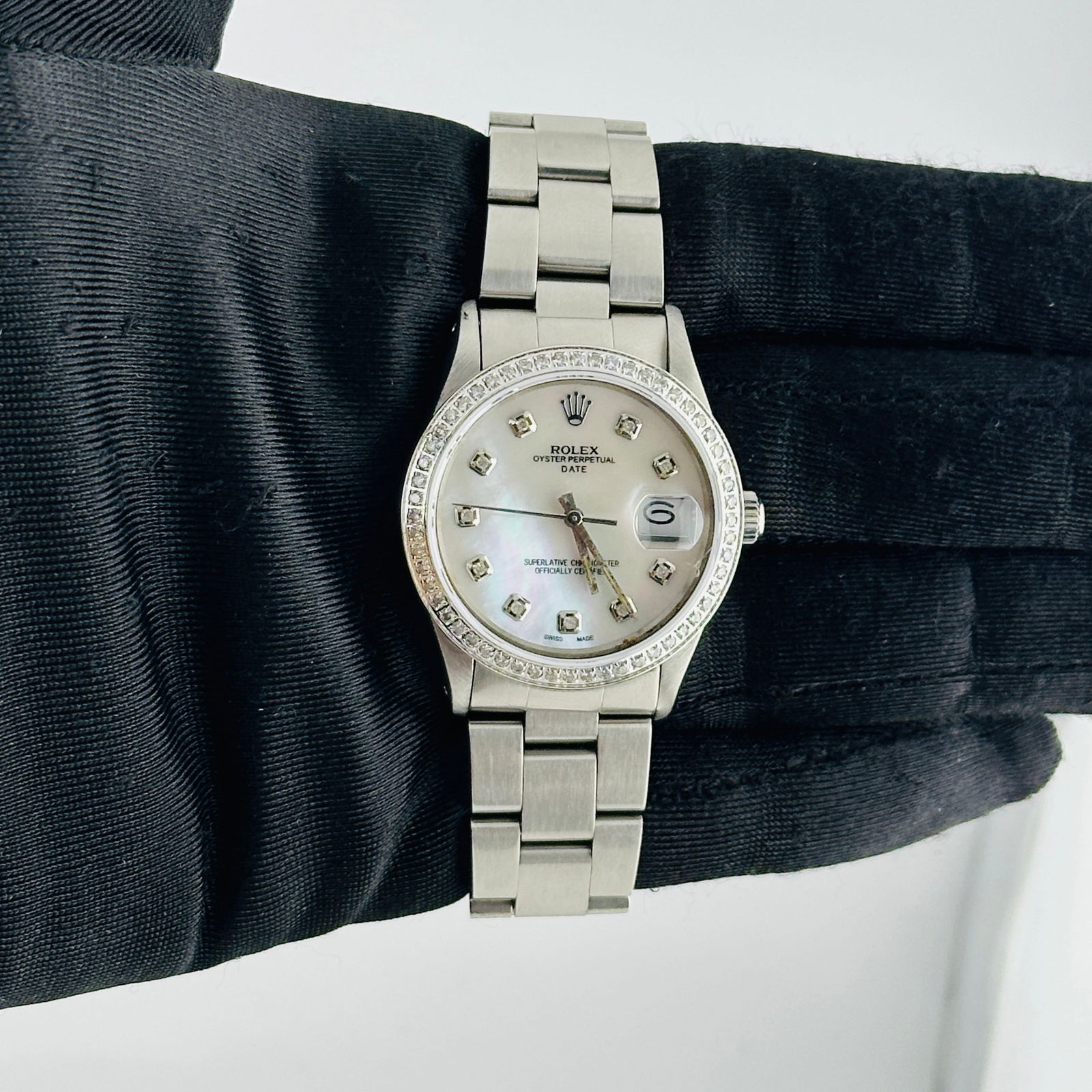 Rolex 15010 Oyster Perpetual Date Aftermarket White MOP Diamond Dial Watch: Rolex 15010 Oyster Perpetual Date Aftermarket White MOP Diamond Dial Watch This Rolex Oyster Perpetual Date watch features an aftermarket white mother-of-pearl dial adorned with diamond hour markers.