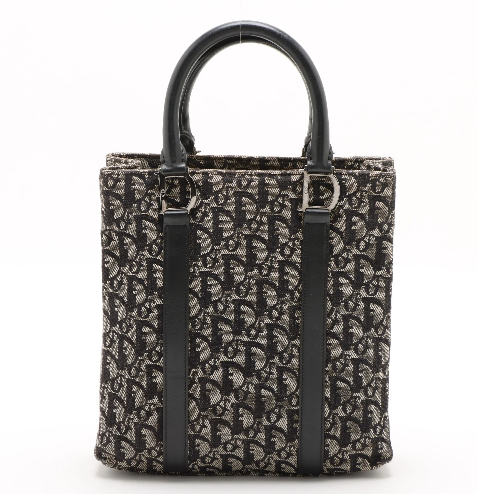 Dior Trotteur Canvas Tote Handbag with Signature Monogram Design: Dior Trotteur Canvas Tote Handbag with Signature Monogram Design This pre-owned Christian Dior Trotteur tote bag features a classic design and retains its luxury appeal despite visible signs of use. T