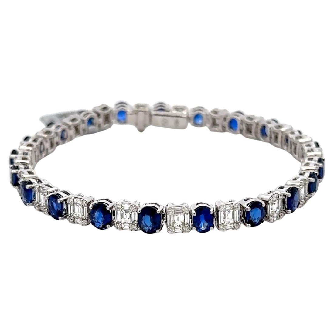 Stunning 18K White Gold Sapphire Diamond Tennis Bracelet 11.80 Carats: Stunning 18K White Gold Sapphire Diamond Tennis Bracelet 11.80 Carats This exquisite tennis bracelet features an elegant arrangement of 21 oval blue sapphires and 189 diamonds, crafted from 18K white