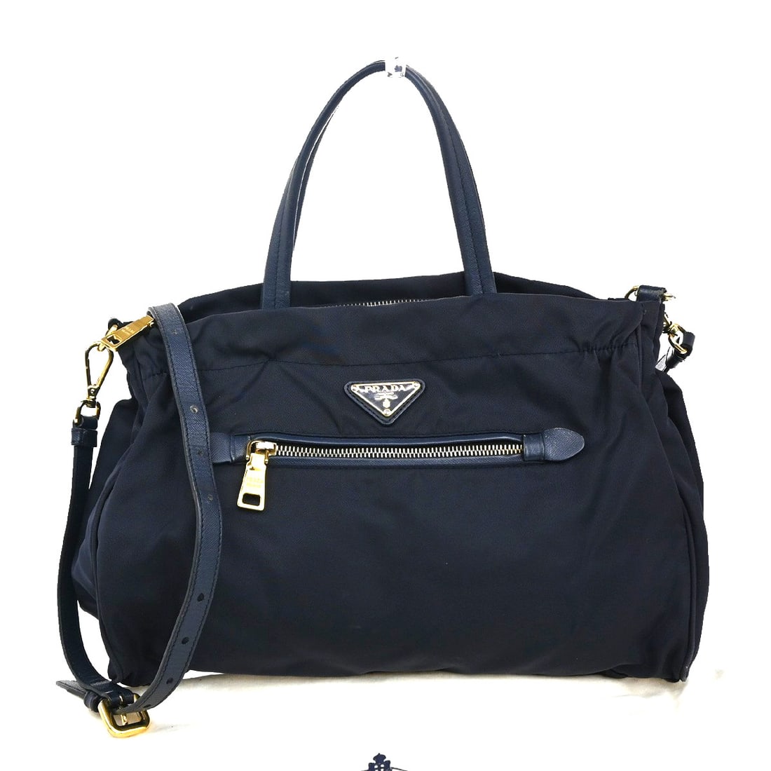 Navy Convertible Shoulder Tote by Prada with Zipper Closure: Navy Convertible Shoulder Tote by Prada with Zipper Closure This pre-owned Prada Zip Convertible Shopping Tote in navy is a stylish handbag designed for women. It features a shoulder strap and offers