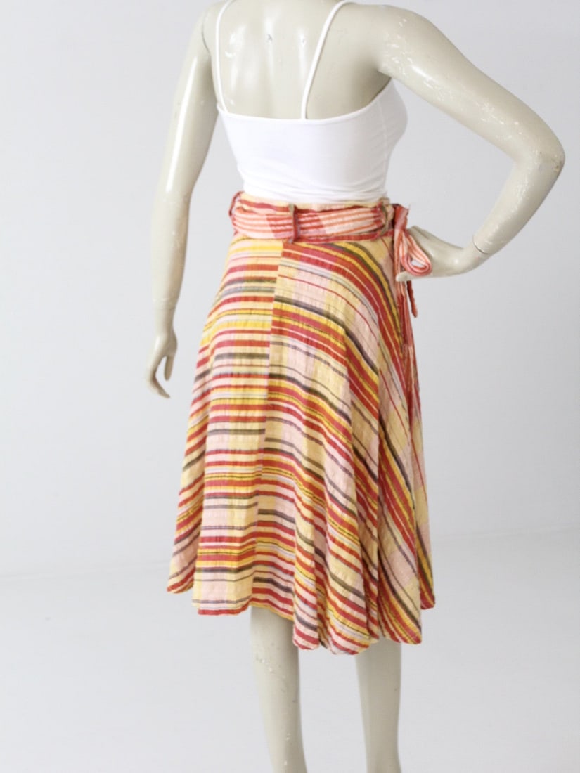 1970s Vintage Striped Gauze Cotton Wrap Skirt: 1970s Vintage Striped Gauze Cotton Wrap Skirt This vintage 1970s gauze cotton wrap skirt is a vibrant addition to your wardrobe. Crafted from soft cotton, it features an eye-catching array of stripes