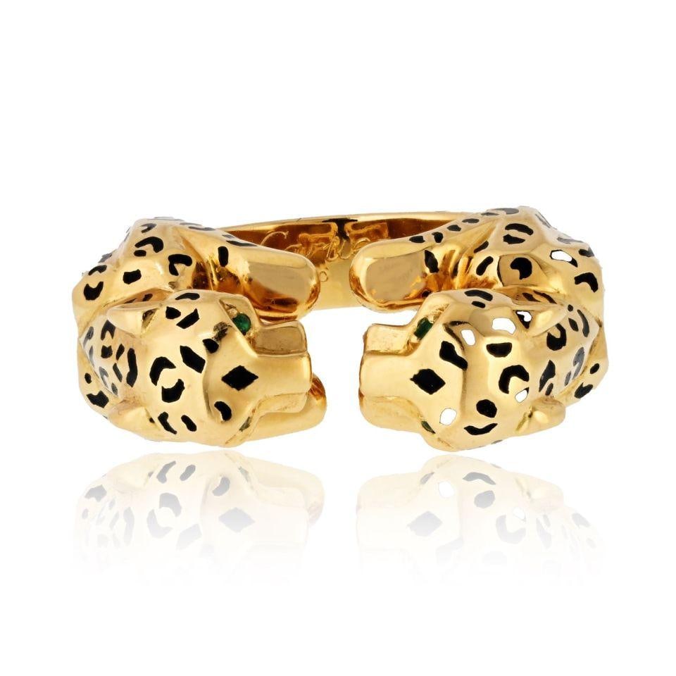 Cartier 18K Yellow Gold Double Panther Ring with Emerald Eyes: Cartier 18K Yellow Gold Double Panther Ring with Emerald Eyes Indulge in the wild elegance of this stunning Cartier double panther spotted head ring, crafted from luxurious 18K yellow gold. This exqui