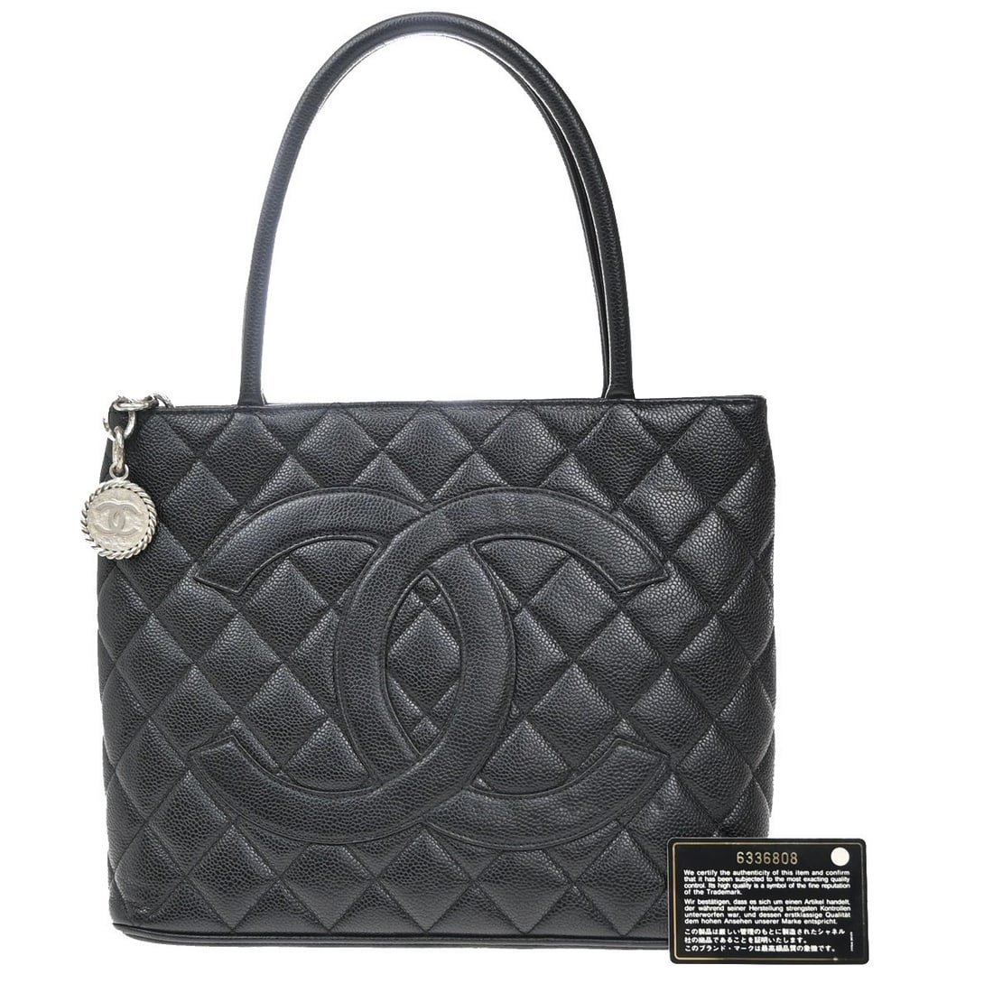Black Medallion Tote Bag from Chanel with Leather Scent: Black Medallion Tote Bag from Chanel with Leather Scent This Chanel Medallion Tote is a stylish and functional tote bag designed for women. The exterior shows signs of scuffing, dirt, stains, and scra