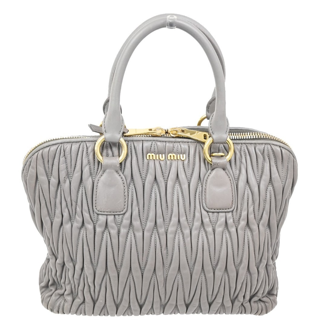 Purple Madras Bowler Shoulder Handbag by Miu Miu: Purple Madras Bowler Shoulder Handbag by Miu Miu This pre-owned Miu Miu Madras Bowler Bag in purple features a structured silhouette with dual handles and a shoulder strap. The bag shows noticeable si