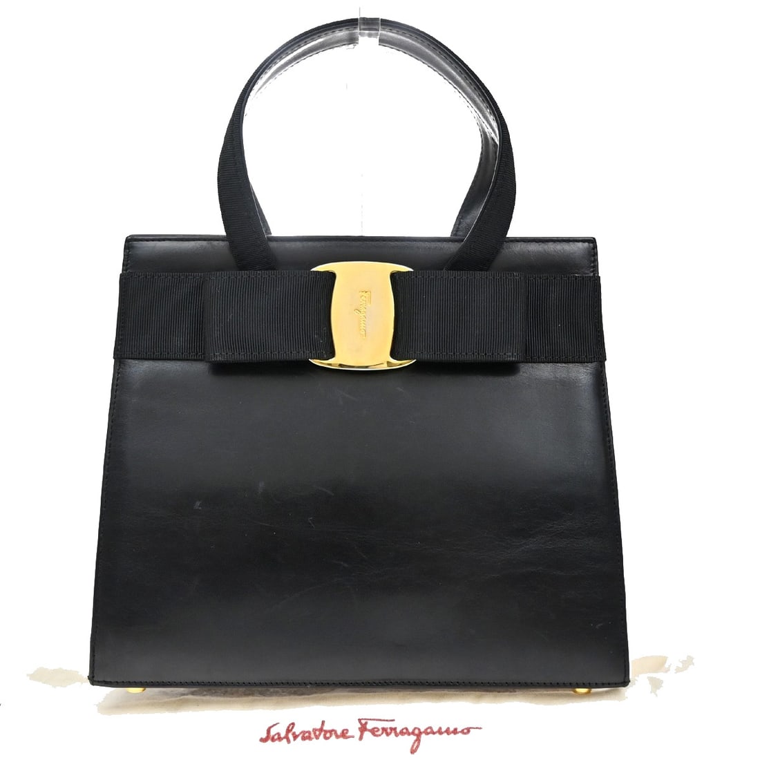 Convertible Vara Bow Black Tote Bag by Salvatore Ferragamo: Convertible Vara Bow Black Tote Bag by Salvatore Ferragamo This Salvatore Ferragamo convertible Vara Bow tote in black is a stylish handbag designed for women. It features some scuffs, stains, wrinkle