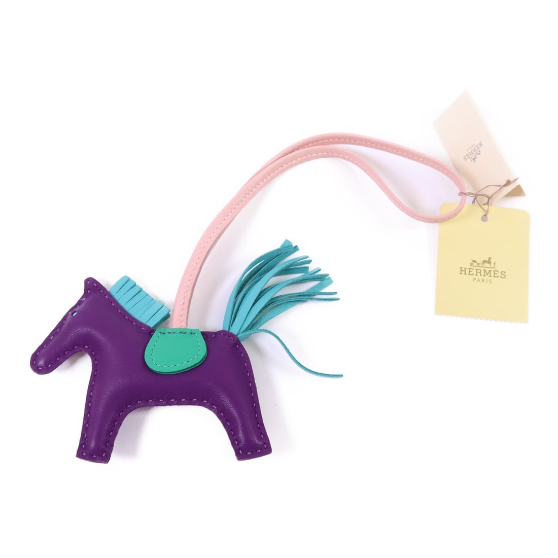 HERMES Rodeo PM Charm in Violet Lambskin Leather: HERMES Rodeo PM Charm in Violet Lambskin Leather Introducing the exquisite HERMES Rodeo PM Charm crafted from luxurious lambskin leather in a striking violet hue. This charming accessory is not only a