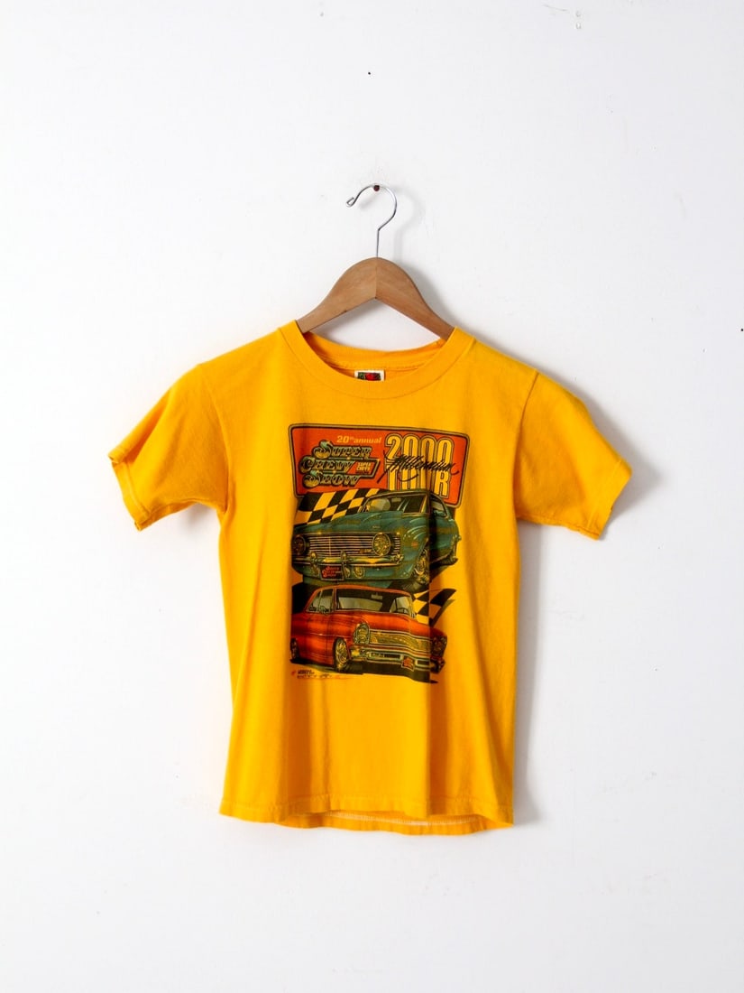 Vintage Super Chevy Show 20th Anniversary Graphic Tee: Vintage Super Chevy Show 20th Anniversary Graphic Tee Celebrate automotive culture with this vintage Super Chevy Show t-shirt from the 20th annual event. This golden yellow graphic tee features eye-ca