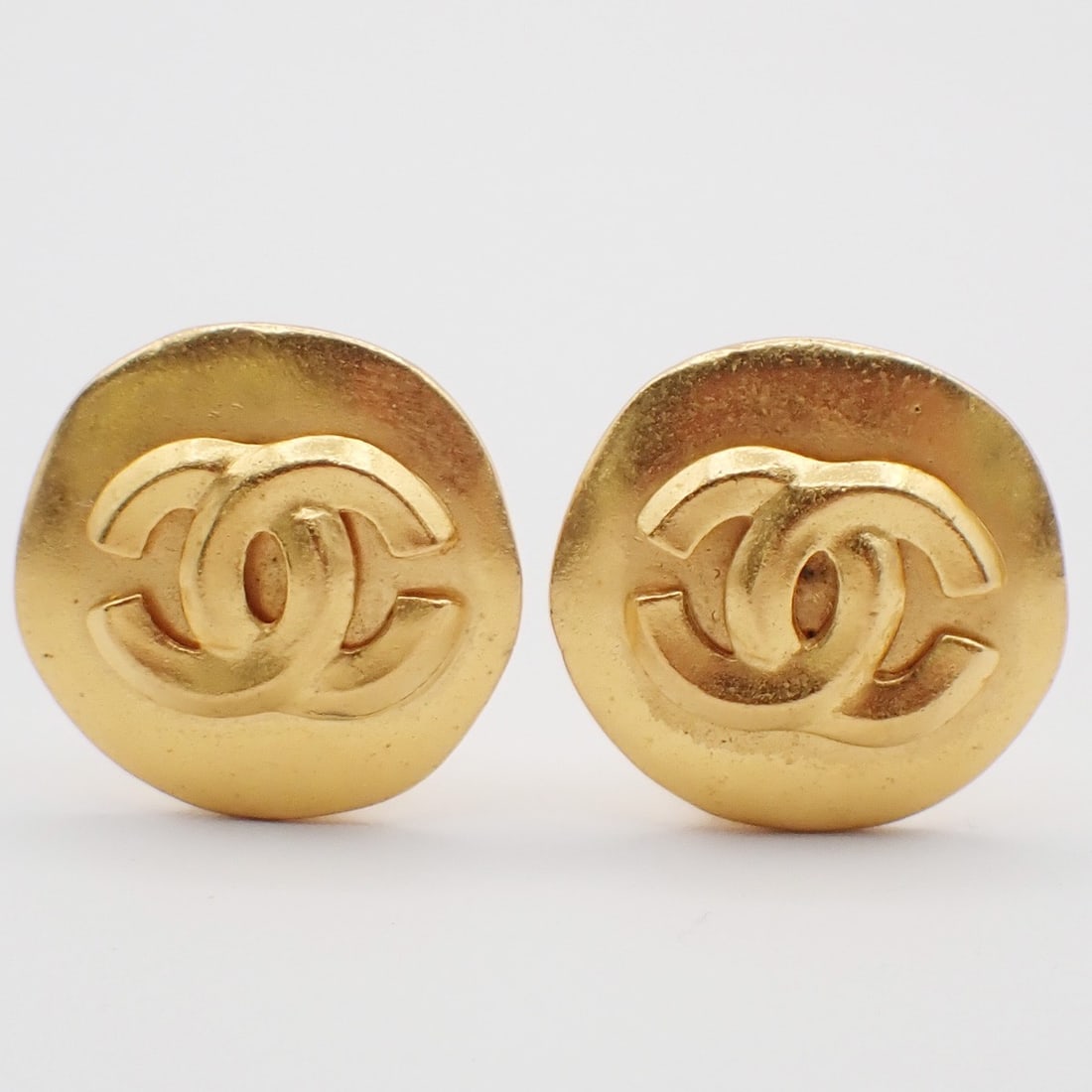 Vintage Chanel CC Logo Gold Tone Clip-On Earrings: Vintage Chanel CC Logo Gold Tone Clip-On Earrings These vintage Chanel CC round clip-on earrings feature a classic gold finish. Designed for women, they are in good condition with minor signs of wear,