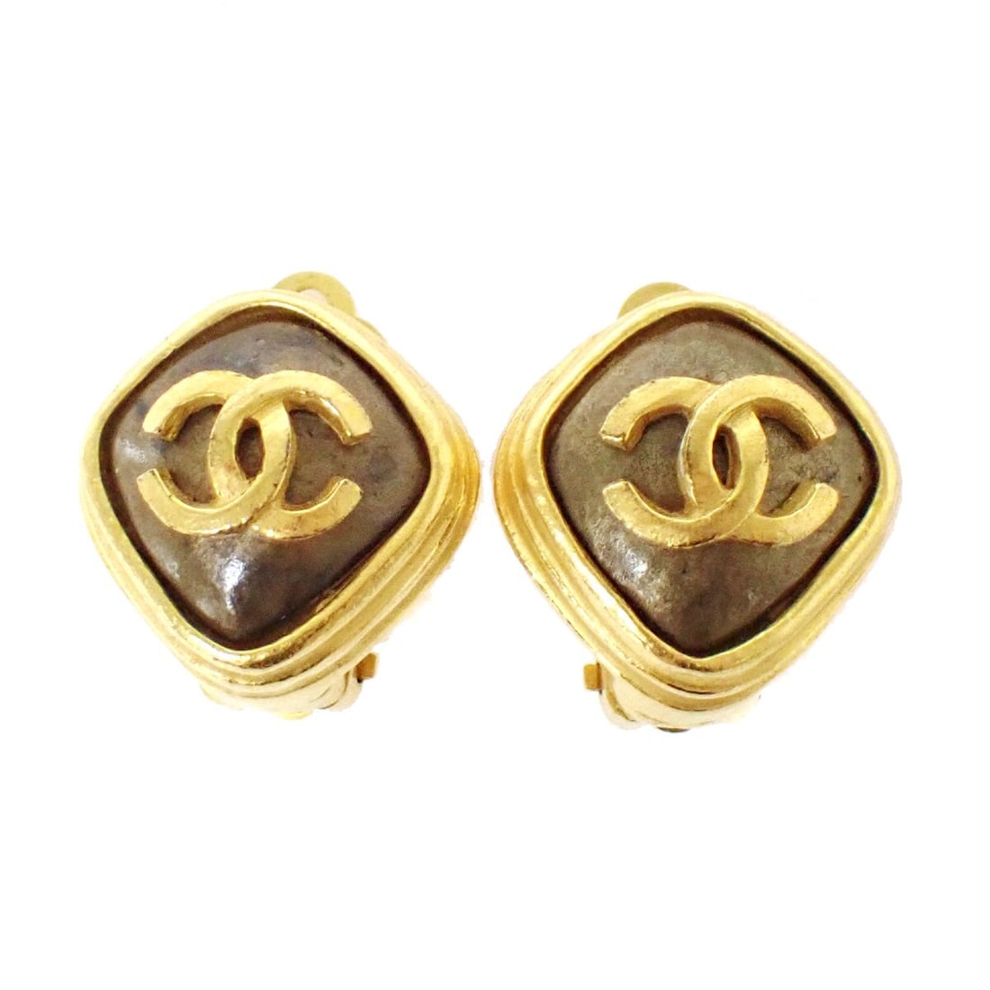 Brown CC Logo Clip Earrings by Chanel: Brown CC Logo Clip Earrings by Chanel These Chanel CC clip-on earrings in brown are designed for women and feature the iconic CC logo. They are in good condition with some scuffs, dirt, and scratches