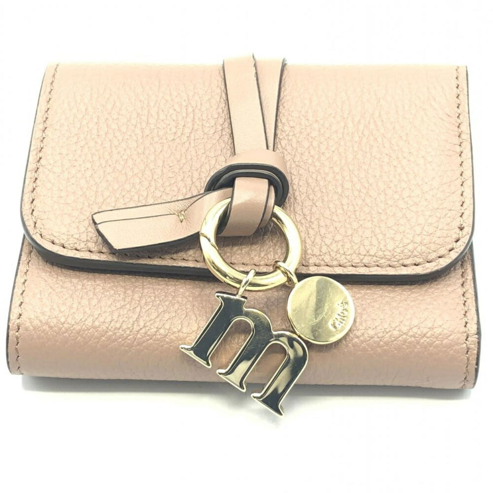 Beige Alphabet Trifold Wallet by Chloe: Beige Alphabet Trifold Wallet by Chloe This Chloe Alphabet Trifold Wallet in beige is a pre-owned accessory designed for women. It is in very good condition, exhibiting minimal signs of use such as li