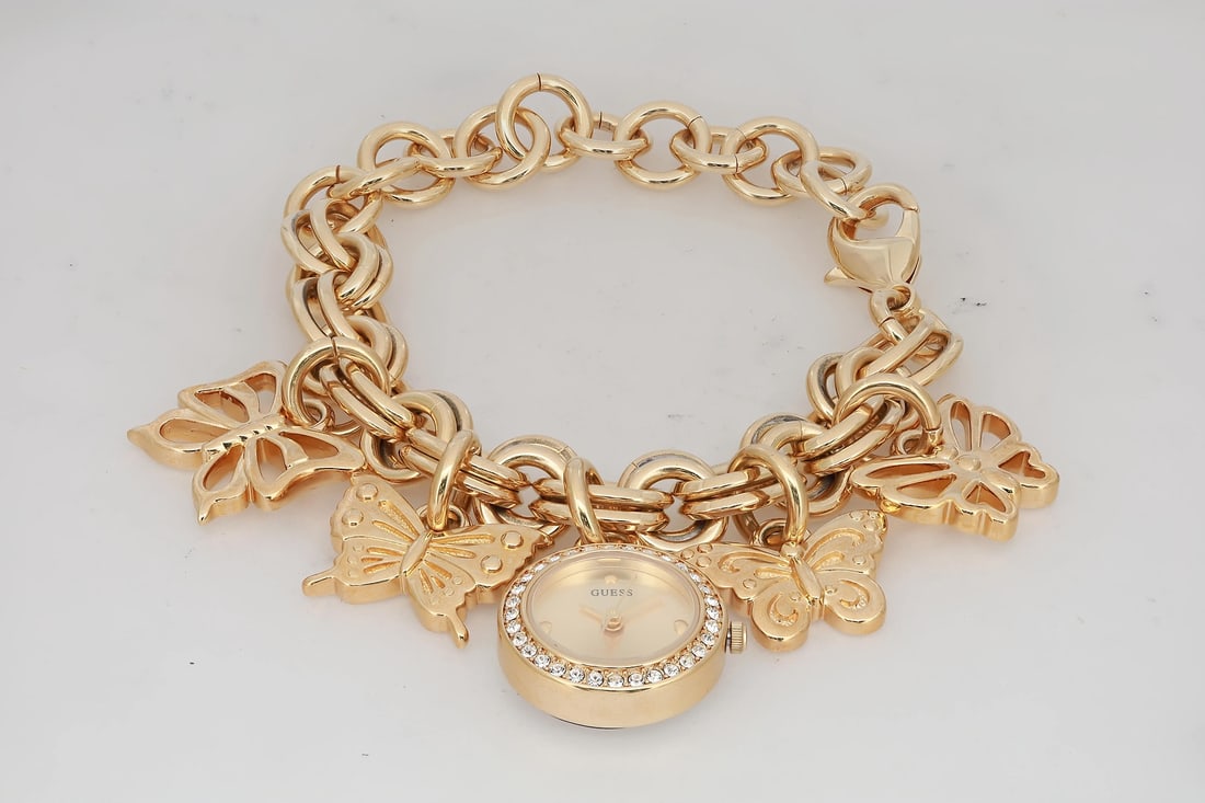 GUESS Charm 20mm Gold-Tone Quartz Watch with Champagne Dial: GUESS Charm 20mm Gold-Tone Quartz Watch with Champagne Dial This elegant Guess Charm wristwatch is perfect for dress or formal occasions. Featuring a stylish champagne sunburst dial, this watch showca