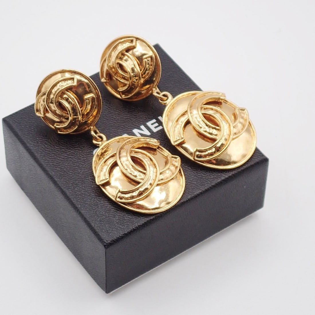 Gold Round Clip-On Earrings with CC Logo Chanel Vintage: Gold Round Clip-On Earrings with CC Logo Chanel Vintage These vintage Chanel CC round drop clip-on earrings feature a gold tone finish and are designed for women. The earrings are in very good conditi