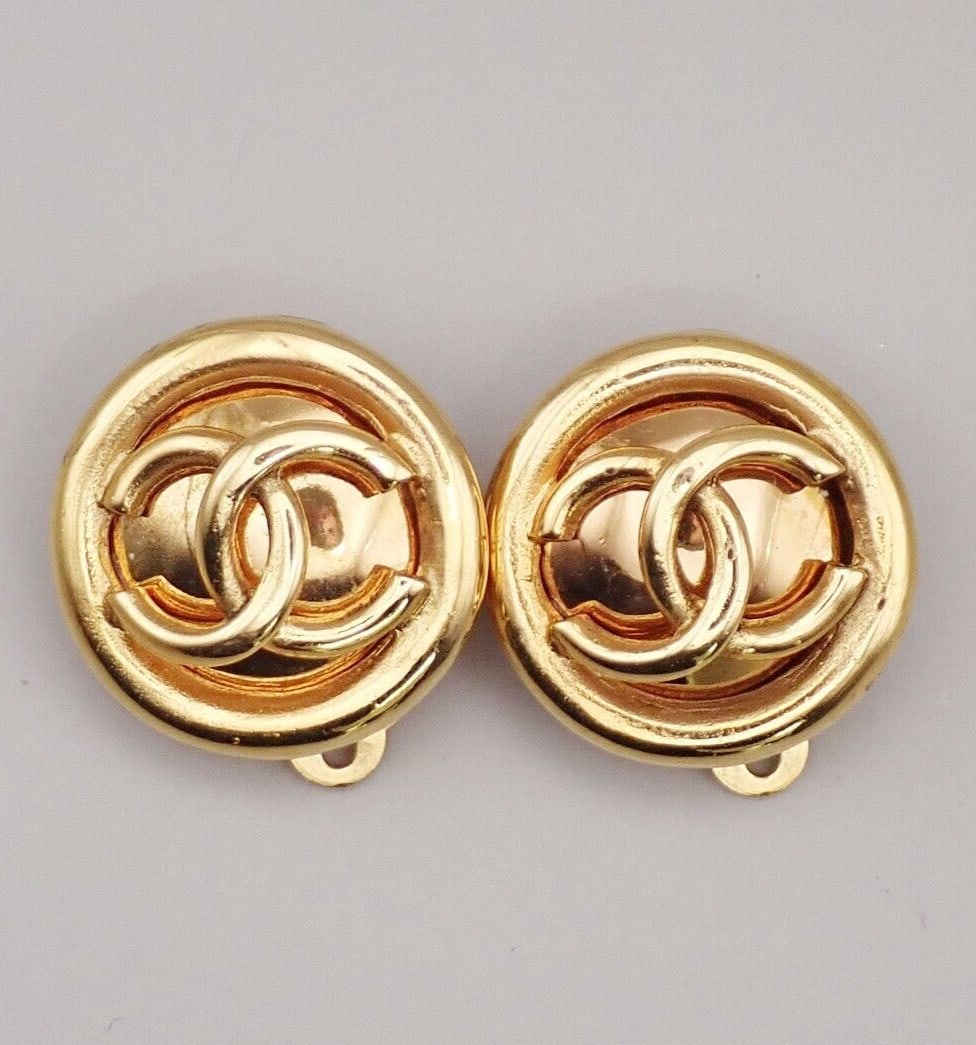 Gold Tone Chanel CC Clip-On Vintage Earrings: Gold Tone Chanel CC Clip-On Vintage Earrings These Chanel vintage CC round clip-on earrings feature a classic gold-tone finish. Suitable for women, they are designed with the iconic CC logo. The earri