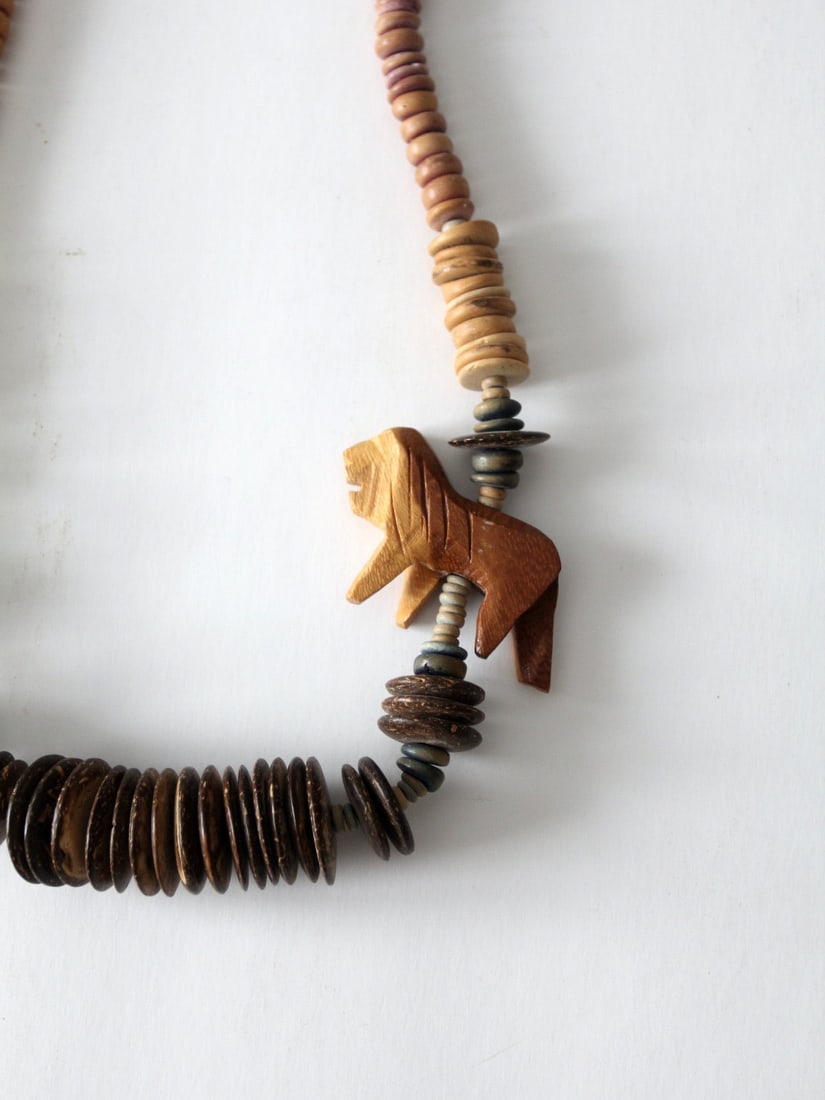 Vintage Wooden Bead Necklace with Carved Lion Bead: Vintage Wooden Bead Necklace with Carved Lion Bead Make a bold statement with this vintage wooden bead necklace. Crafted with chunky carved wood, it features a striking lion bead alongside graduated r