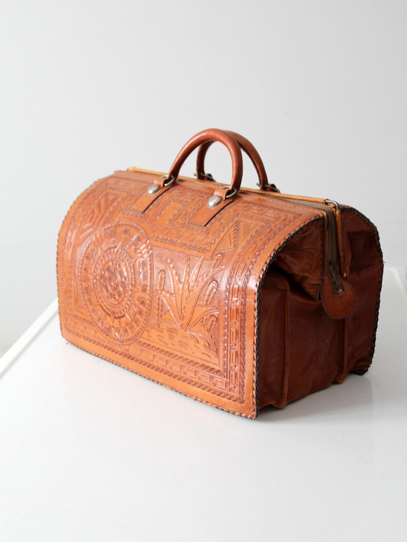 Vintage Brown Tooled Leather Satchel Bag with Zipper Closure: Vintage Brown Tooled Leather Satchel Bag with Zipper Closure Discover the charm of this Vintage Tooled Leather Satchel Bag, a beautifully crafted duffle bag that showcases intricate tooling. Made from