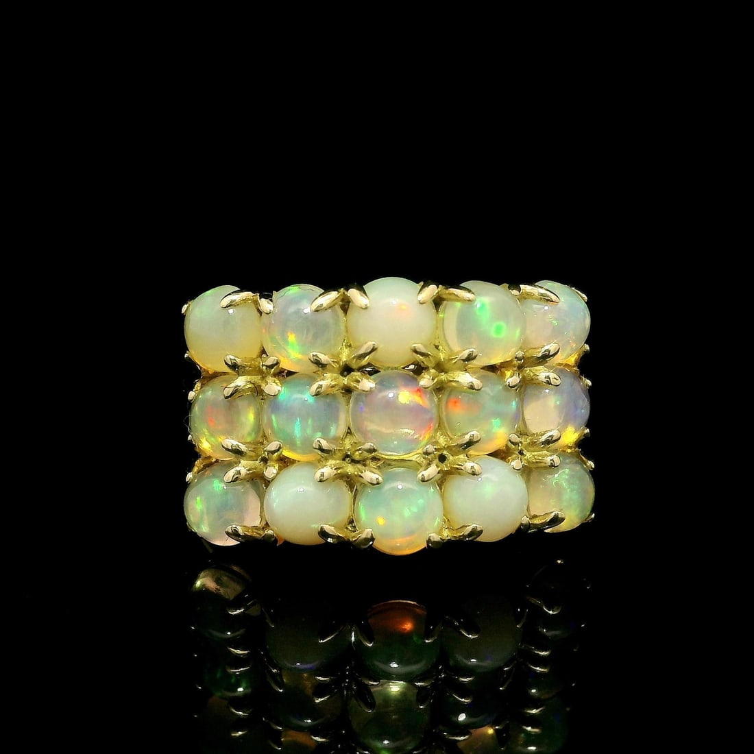 18k Yellow Gold Three Row Opal Cocktail Ring with Natural Stones: 18k Yellow Gold Three Row Opal Cocktail Ring with Natural Stones This stunning cocktail ring features a striking design with a three-row wide solid band crafted from 18k yellow gold. The centerpiece i