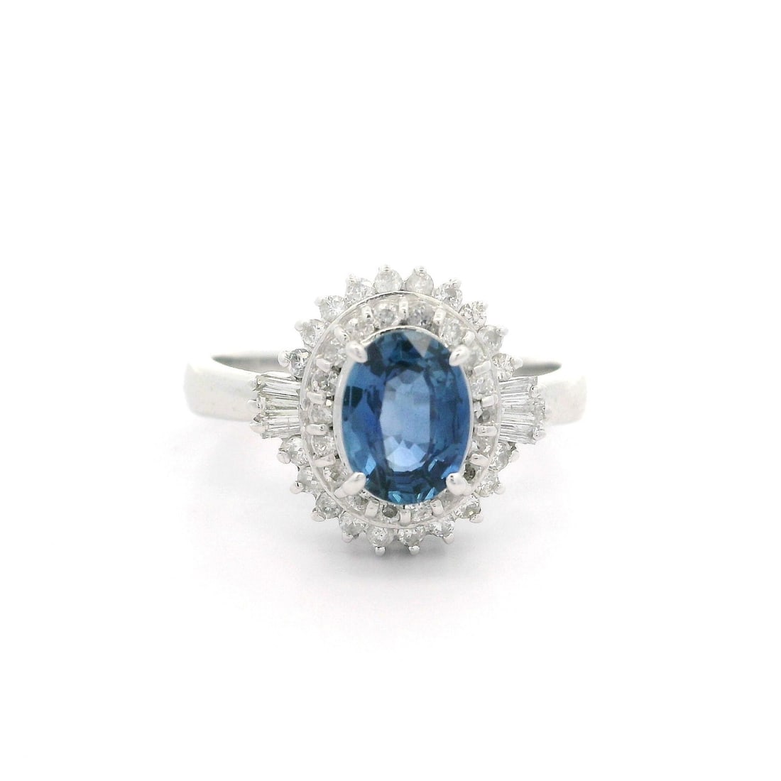 Platinum Ballerina Ring 1.41ctw Oval Sapphire Diamond Accent: Platinum Ballerina Ring 1.41ctw Oval Sapphire Diamond Accent This exquisite ballerina style ring showcases a stunning oval sapphire at its center, measuring 7.1x5.3mm and weighing 1.01 carats. Surroun