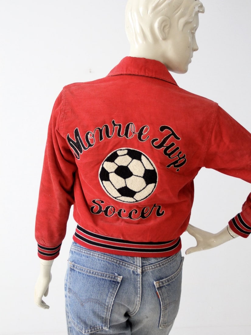 Vintage 1980s Red Corduroy Soccer Jacket Monroe Township Team: Vintage 1980s Red Corduroy Soccer Jacket Monroe Township Team Step back into the vibrant 1980s with this vintage youth soccer jacket, perfect for fans and collectors alike. Crafted from soft red cordu
