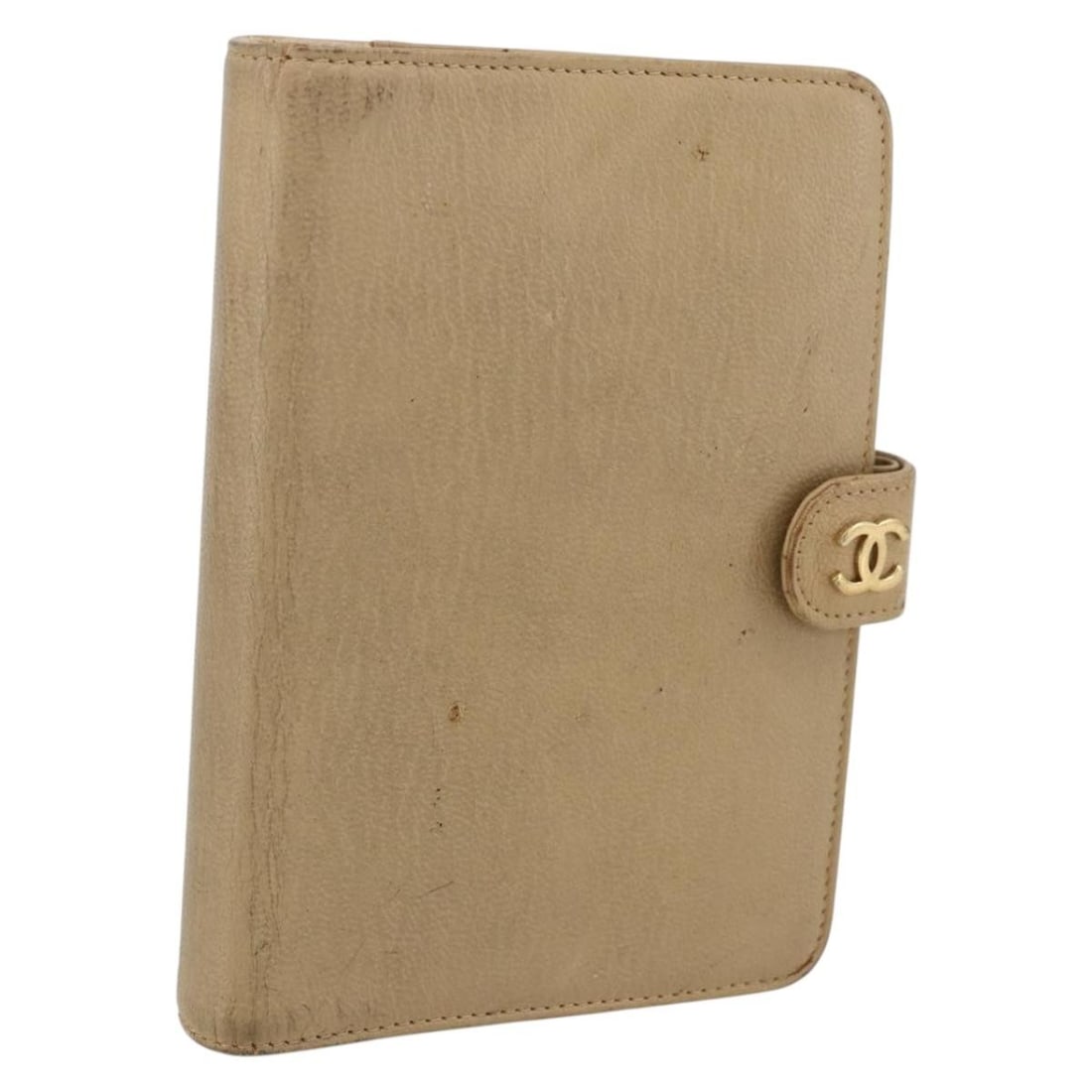 Beige Leather Day Planner Cover with Gold CC Logo by CHANEL: Beige Leather Day Planner Cover with Gold CC Logo by CHANEL This CHANEL day planner cover is crafted from beige leather with gold-tone accents. It features a compact design and includes a guarantee ca