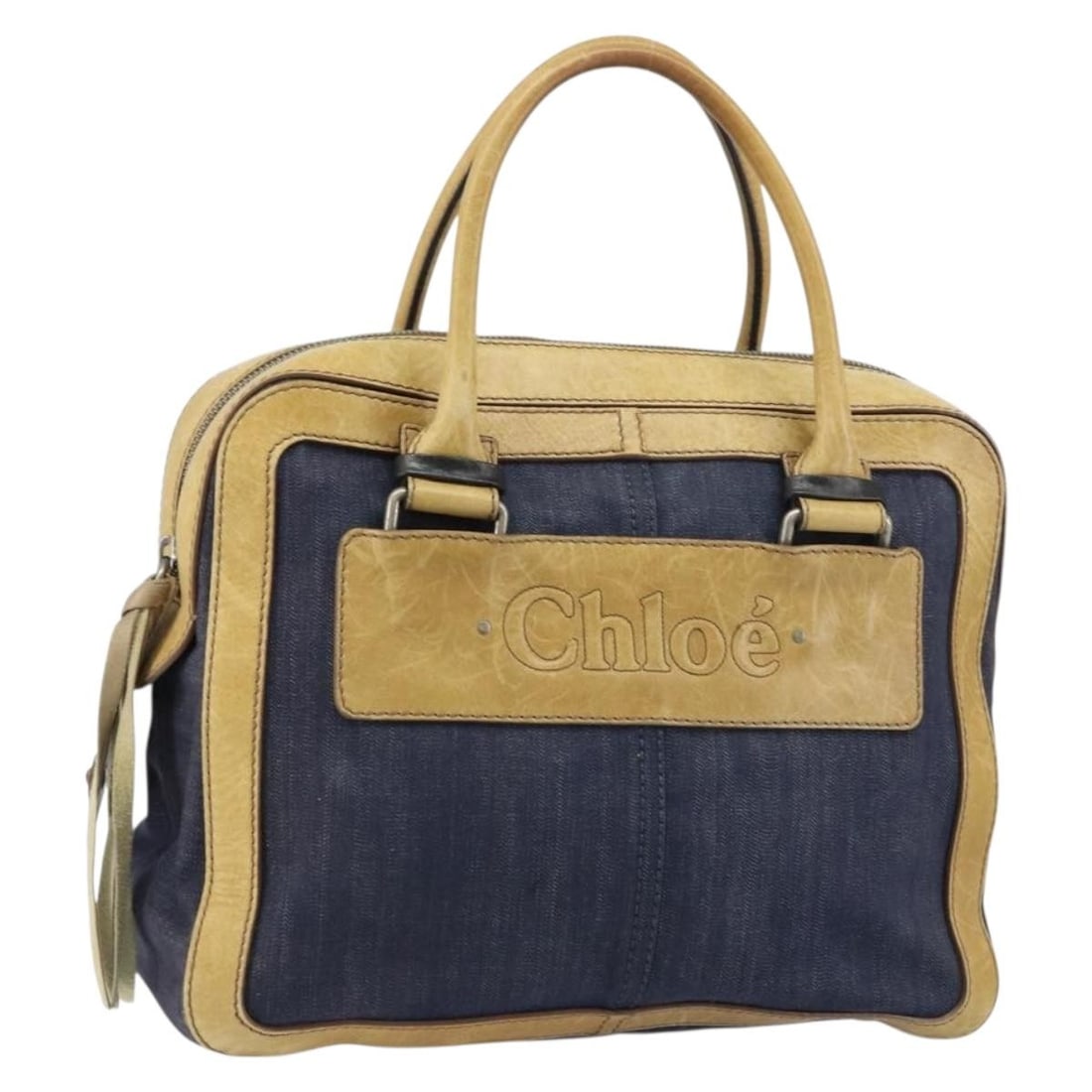 Chloe Canvas Tote in Blue Denim Shade Made in Romania: Chloe Canvas Tote in Blue Denim Shade Made in Romania This Chloe tote bag features a blue canvas exterior and is crafted in Romania. The bag shows significant signs of use, including out-of-shape area