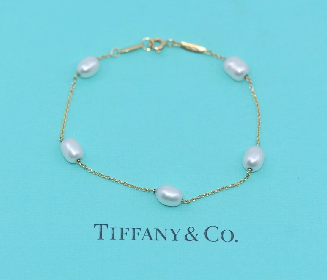18K Yellow Gold Chain Bracelet with Pearls by Tiffany & Co: 18K Yellow Gold Chain Bracelet with Pearls by Tiffany & Co This Tiffany & Co. Pearls by Yard bracelet features a delicate chain design crafted from 18k yellow gold. The bracelet is adorned with pearls