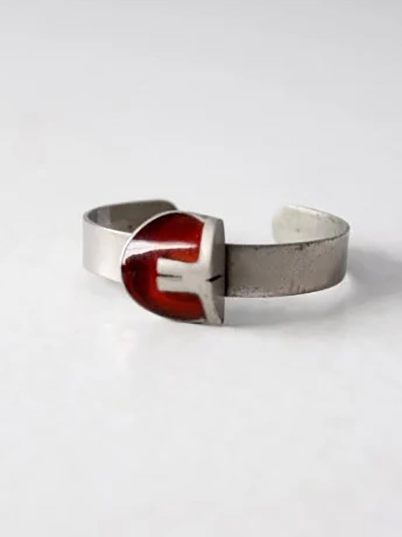 1960s Vintage Mid-Century Modern Silver Tone Cuff Bracelet with Red Inset: 1960s Vintage Mid-Century Modern Silver Tone Cuff Bracelet with Red Inset This vintage 1960s mod cuff exudes mid-century modern elegance with its streamlined silver tone band and striking deep red ins