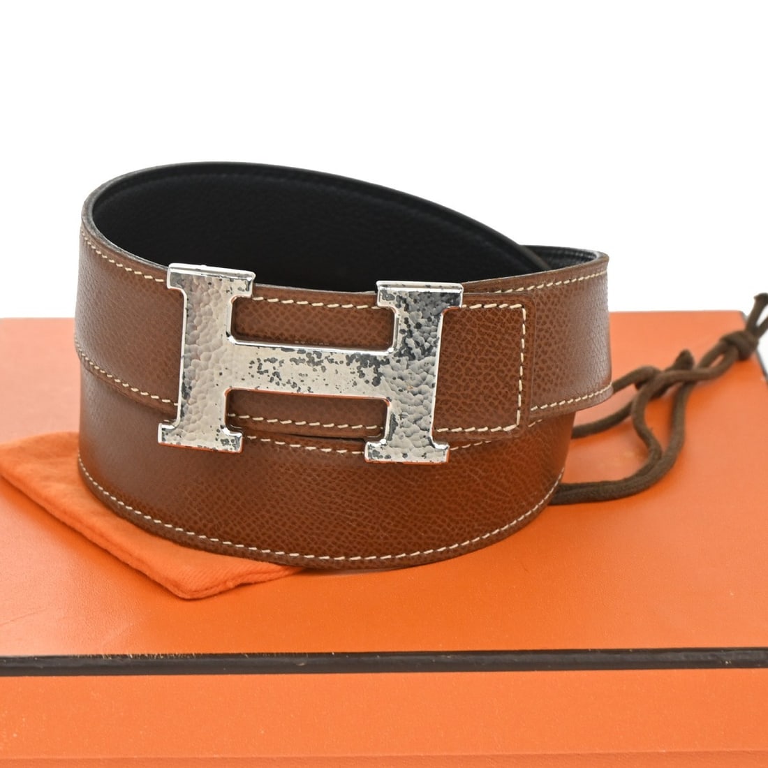 Reversible Black Constance Belt by Hermes: Reversible Black Constance Belt by Hermes This Hermes Constance reversible belt is designed for women and crafted from leather. The pre-owned belt displays signs of use, with scuffs and dirt on the st