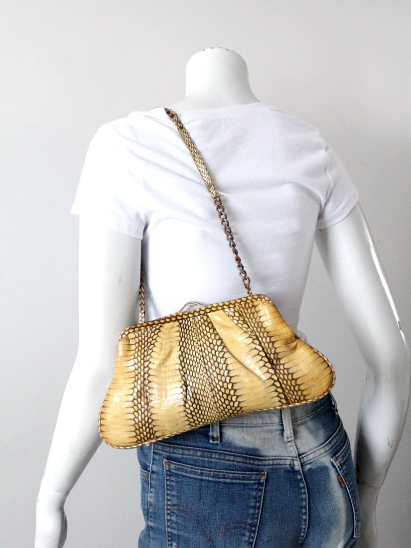 Vintage Leyla Pleated Snakeskin Handbag with Brass Chain Strap: Vintage Leyla Pleated Snakeskin Handbag with Brass Chain Strap Discover the timeless elegance of this Vintage Leyla Snakeskin Handbag. This pleated clutch features a brass chain shoulder strap adorned