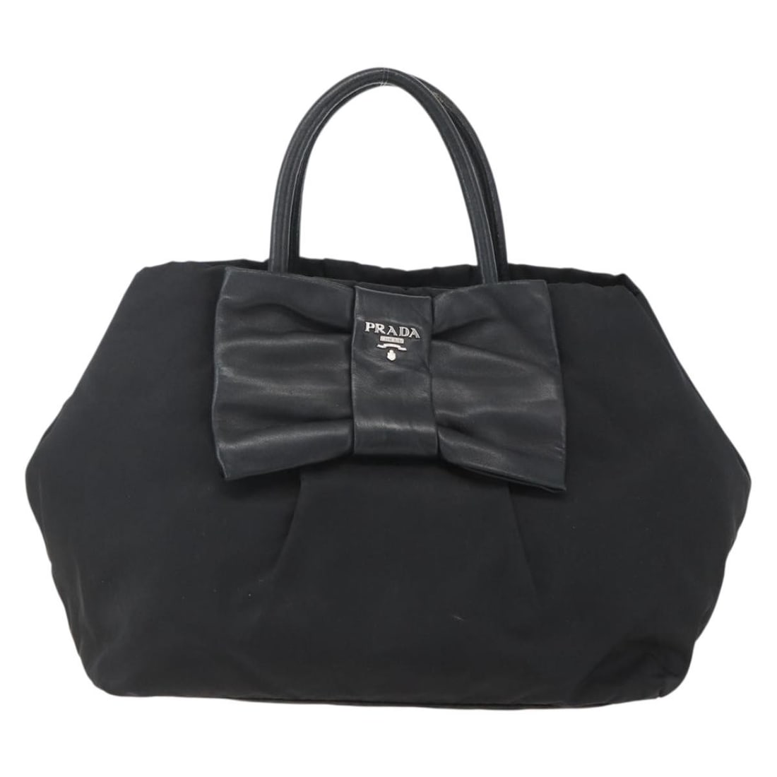 Black Prada Bow Accent Handbag for Women: Black Prada Bow Accent Handbag for Women This Prada Bow Tote in black is a handbag designed for women. The exterior shows signs of use, including surface deformation, rubbing, stains, and some loss of