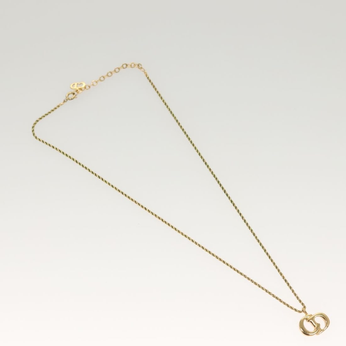 CD Logo Pendant Necklace by Christian Dior in Gold Tone: CD Logo Pendant Necklace by Christian Dior in Gold Tone This pre-owned Christian Dior CD pendant necklace features a gold-tone finish. It is designed for women and shows noticeable signs of wear, incl