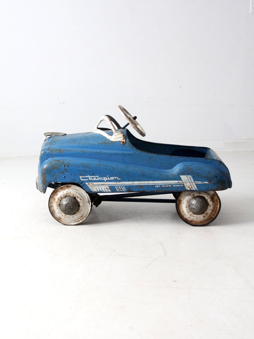 Sky Blue Mid-Century Champion 610 Jet Flow Drive Pedal Car: Sky Blue Mid-Century Champion 610 Jet Flow Drive Pedal Car This charming sky blue Champion 610 Jet Flow Drive pedal car showcases classic white accents and embodies an iconic mid-century design. Its s