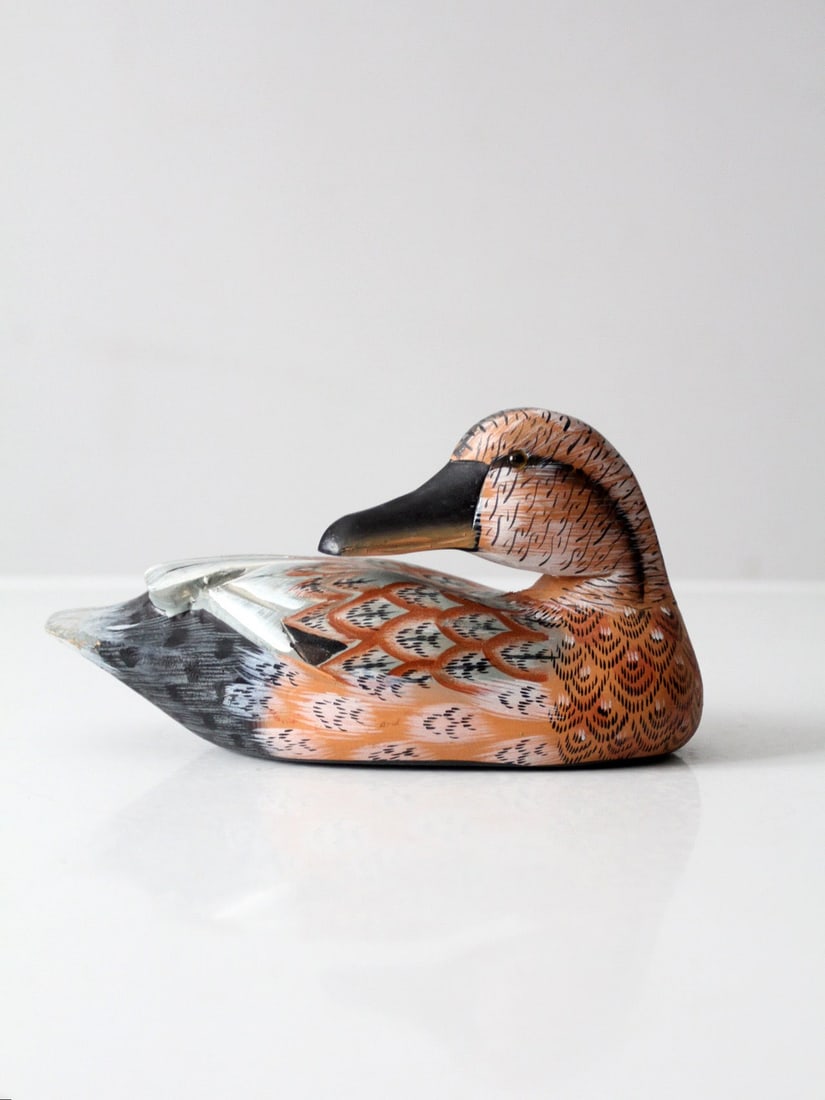 Carved Wooden Duck with Glass Eyes Hand Painted Vintage Accent: Carved Wooden Duck with Glass Eyes Hand Painted Vintage Accent This vintage hand-painted carved wooden duck features glass eyes and a blend of brown and gray tones, providing depth and personality to