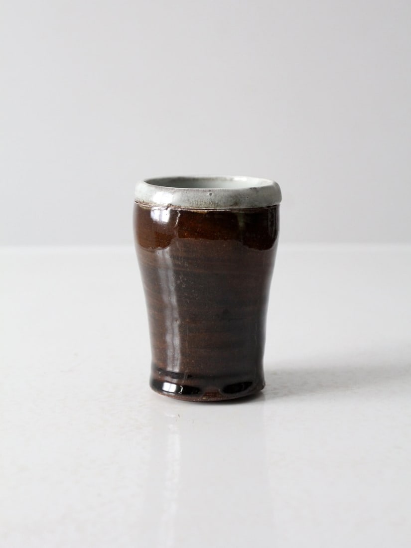 Handmade Vintage Studio Pottery Vase Dual-Toned Glaze: Handmade Vintage Studio Pottery Vase Dual-Toned Glaze This vintage handmade studio pottery vase showcases a striking dual-toned glaze with a tactile, slightly rustic finish. The soft chalk-toned rim s